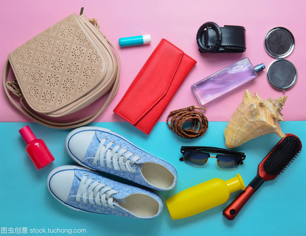 少女时尚春夏饰品: 运动鞋、化妆品、美容卫生用品、一袋、太阳镜上的粉红色蓝色粉彩背景。女人包里有什么?去旅行